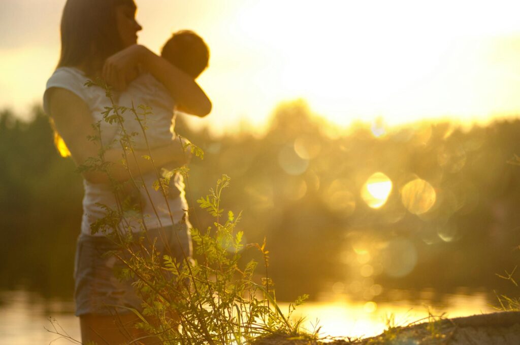 selective focus photography of woman carrying baby
