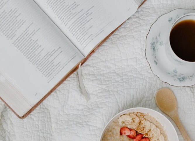 a person reading a book while having cereal
